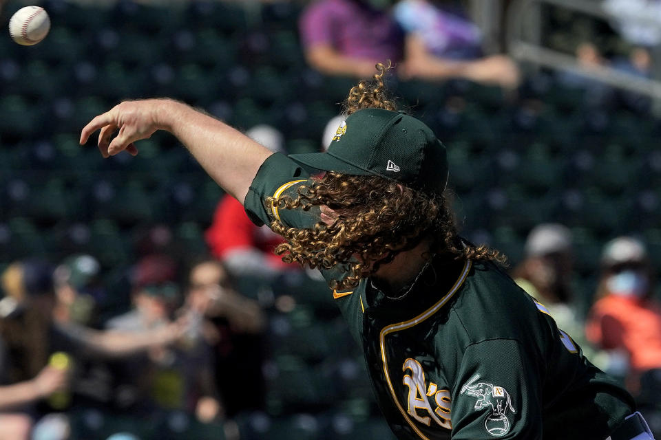 Oakland Athletics pitcher Grant Holmes throws against the Cincinnati Reds during the first inning of a spring training baseball game, Monday, March 1, 2021, in Mesa, Ariz. (AP Photo/Matt York)
