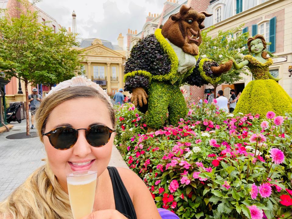 selfie in front of beauty and the beast topiary at epcot