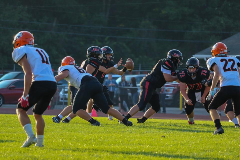 Pleasant's Owen Lowry takes the snap against North Union in last week's football opener at home which the Spartans won 21-15.