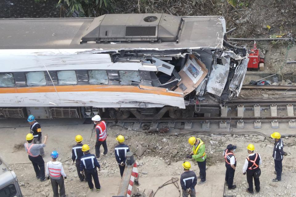 An aerial view shows workers checking a damaged carriage at the site of a derailed train accident on the mountains of Hualien, eastern Taiwan on April 6, 2021. (Photo by Sam Yeh / AFP) (Photo by SAM YEH/AFP via Getty Images)