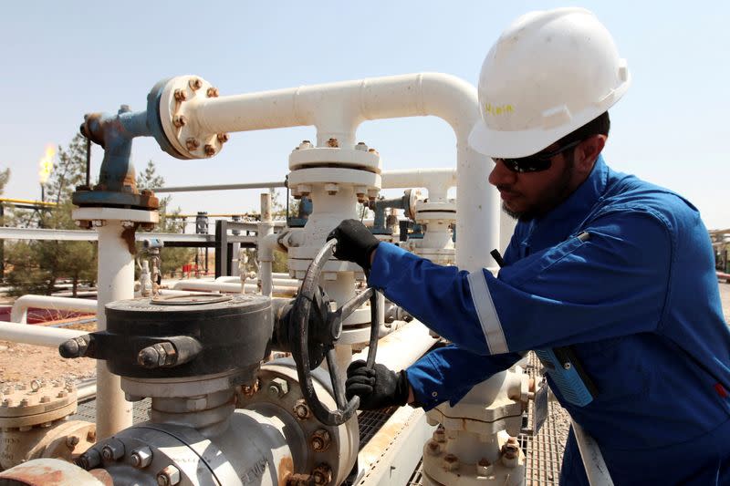 FILE PHOTO: A worker adjusts a valve of an oil pipe at Taq Taq oilfield in Erbil, in Iraq's Kurdistan region