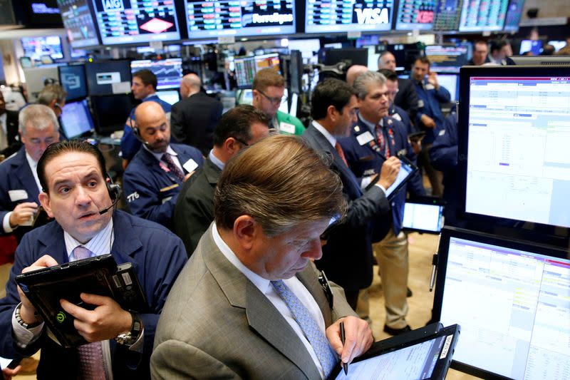 FILE PHOTO: Traders work on the floor of the NYSE