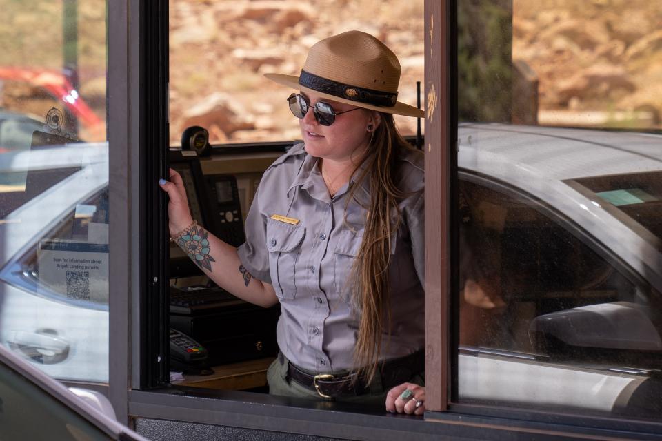 A park ranger greets visitors arriving at Zion National Park.