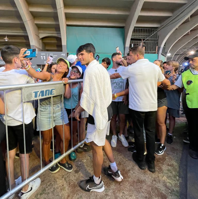 Una acción que se repitió cada tarde en el Argentina Open: Alcaraz posando para las fotos; a su lado, de remera blanca, Evaristo Sanguinetti, la persona de seguridad que lo acompaña las 24 horas