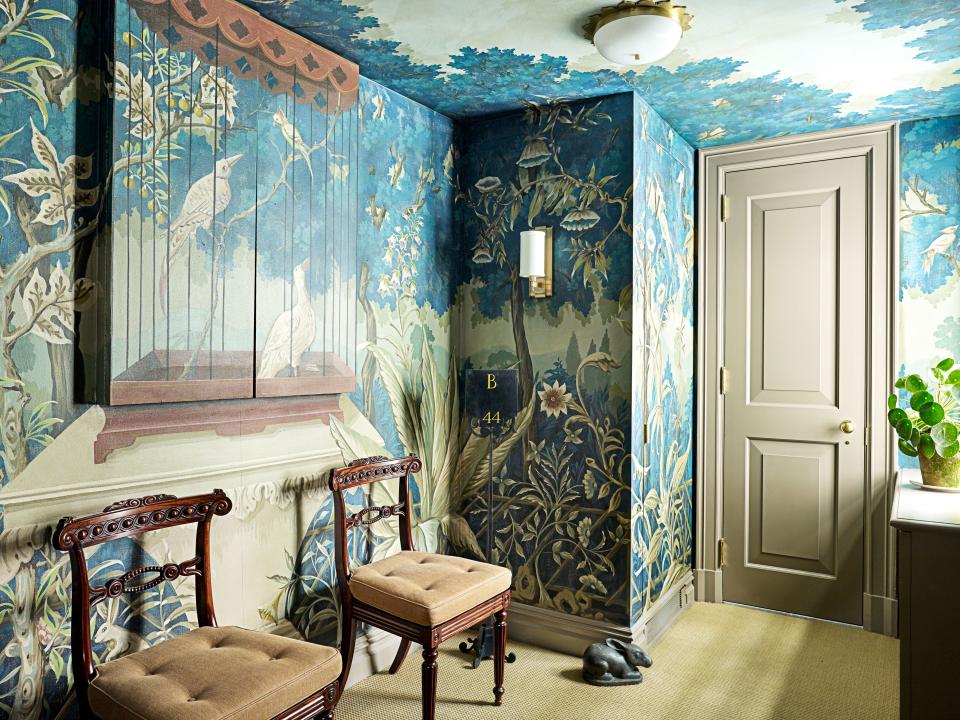 A hand-painted mural by Bob Christian Decorative Art covers an anteroom’s walls and ceiling. English regency side chairs; wood sculpture by Christopher Hewat; Indonesian soapstone rabbit sculpture; sconce by Hudson Valley Lighting; ceiling light by Alexa Hampton from Visual Comfort; sisal carpet by Stark.