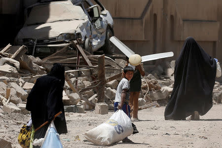 Displaced Iraqi people carry their belongings as they flee from western Mosul, Iraq May 31, 2017. REUTERS/Alkis Konstantinidis