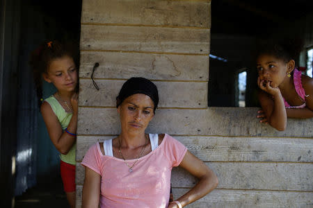 Ariana Alarcon (C), 29, sits outside her home in the village of Santo Domingo, in the Sierra Maestra, Cuba, March 29, 2018. "We had more trust in Fidel. It seems to me that things are worse now. Transportation is worse and prices are higher," Alacron said. REUTERS/Alexandre Meneghini