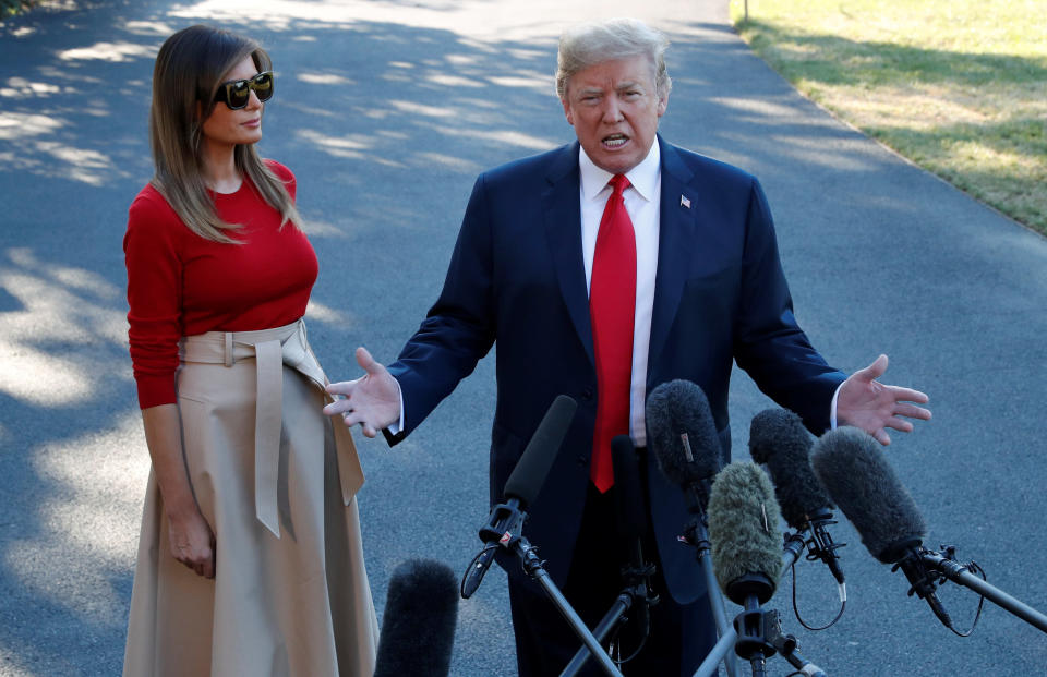 U.S. President Donald Trump speaks with the news media, with first lady Melania Trump standing beside him, before boarding Marine One for travel to Europe from the White House, in Washington, U.S., July 10, 2018. REUTERS/Leah Millis