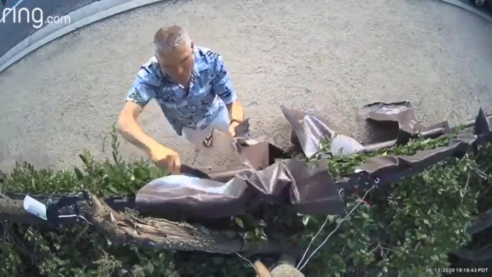 Darrin Stone on camera using a knife to take down a sign hung from a homeowner's fence facing Westlake Boulevard in Thousand Oaks, Calif. (Ventura County Sheriff's Office)