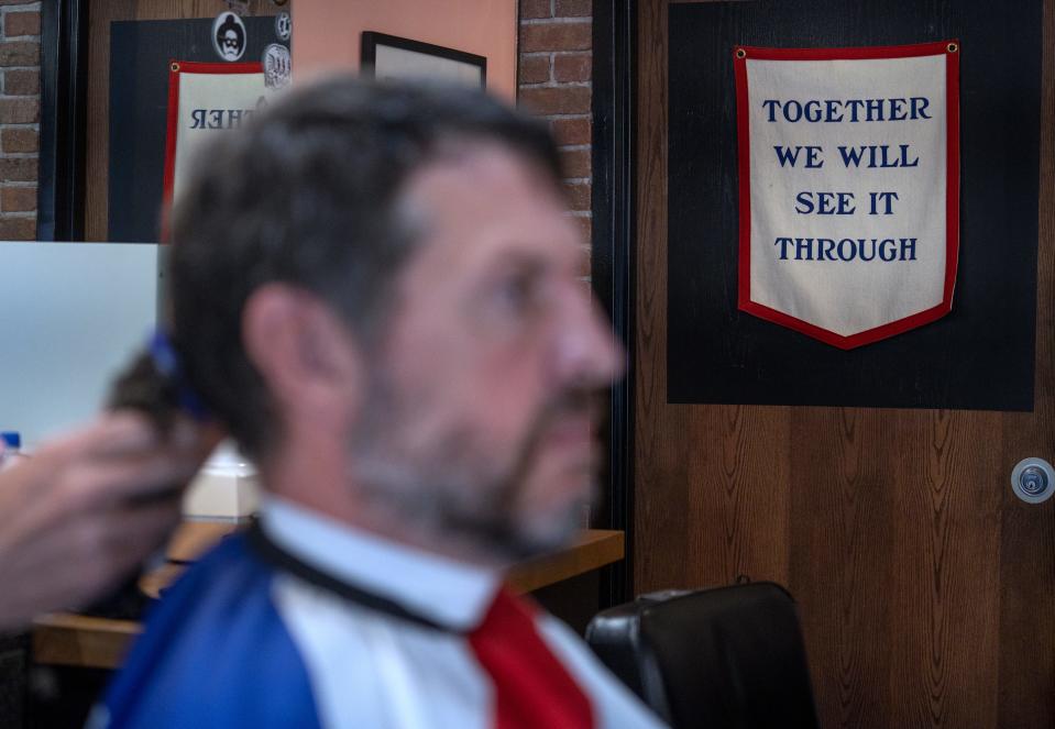 An inspirational saying is seen on the wall as Bill Oesterle gets his hair cut Wednesday, June 8, 2022 at Warfleigh Barber Shop in Broad Ripple. Oesterle has ALS, or amyotrophic lateral sclerosis, an incurable disease that affects parts of the nervous system, affecting muscle movement. It is also called Lou Gehrig's disease.