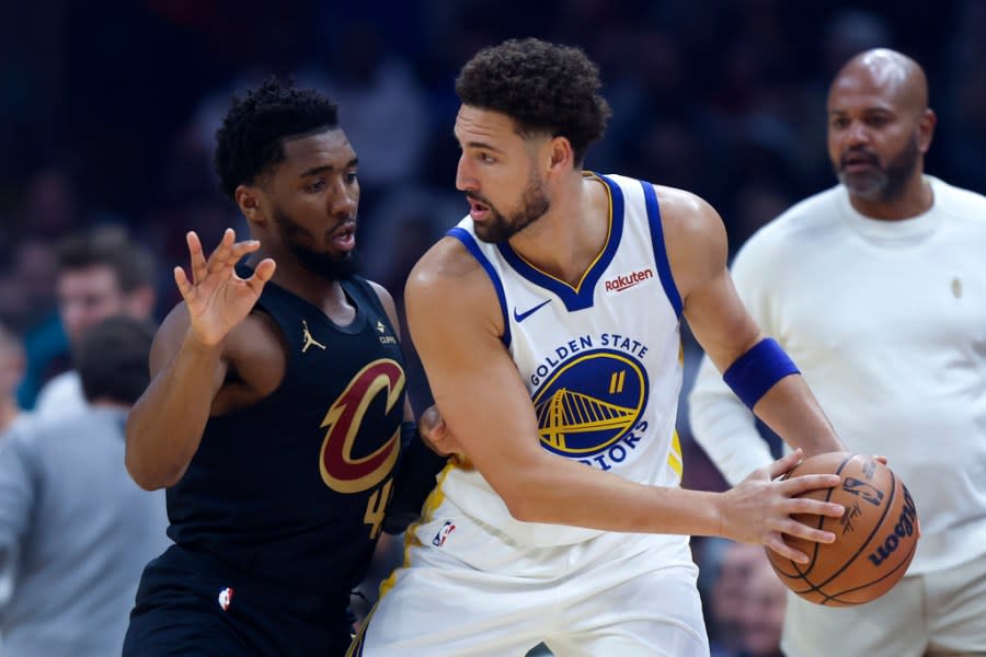 Golden State Warriors guard Klay Thompson (11) plays against Cleveland Cavaliers guard Donovan Mitchell, left, during the first half of an NBA basketball game, Sunday, Nov. 5, 2023, in Cleveland. (AP Photo/Ron Schwane)