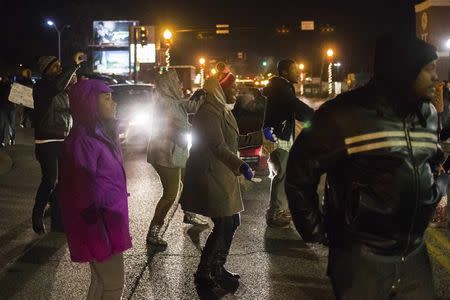 Protesters, demanding the criminal indictment of a white police officer who shot dead an unarmed black teenager in August, block traffic while shouting at police outside the Ferguson Police Station in Missouri November 20, 2014. REUTERS/Adrees Latif