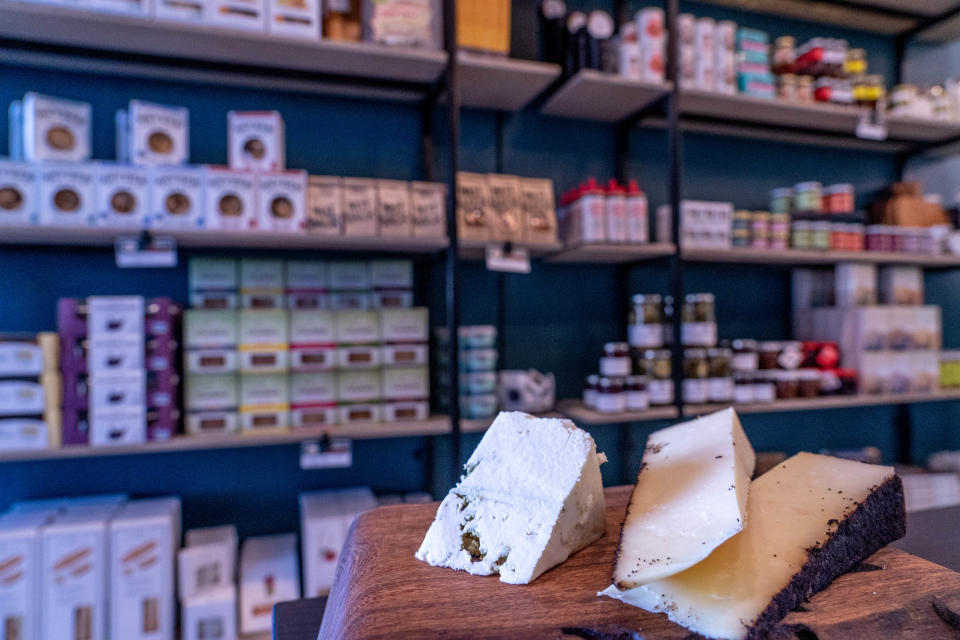 Wedges of Maytag blue cheese, left, and Beehive Cheese Company's Barely Buzzed cheddar cheese rubbed with espresso and lavender are displayed at Shea Cheese's new storefront in Phoenix on Nov. 10, 2022.