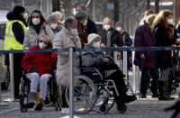 People queue in front of the vaccination center against the COVID -19 disease at the 'Arena Treptow' in Berlin, Germany, Monday, Feb. 1, 2021. Chancellor Angela Merkel and German state governors are going to talk on Monday with representatives of the pharmaceutical industry beefing up the country's sluggish vaccination campaign. (AP Photo/Michael Sohn)