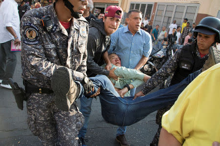 Teodoro Campos, opposition lawmaker and security chief of Venezuelan presidential candidate Henri Falcon, receives help after sustaining injury during a rally with Falcon, in Caracas, Venezuela April 2, 2018. REUTERS/Rayner Pena