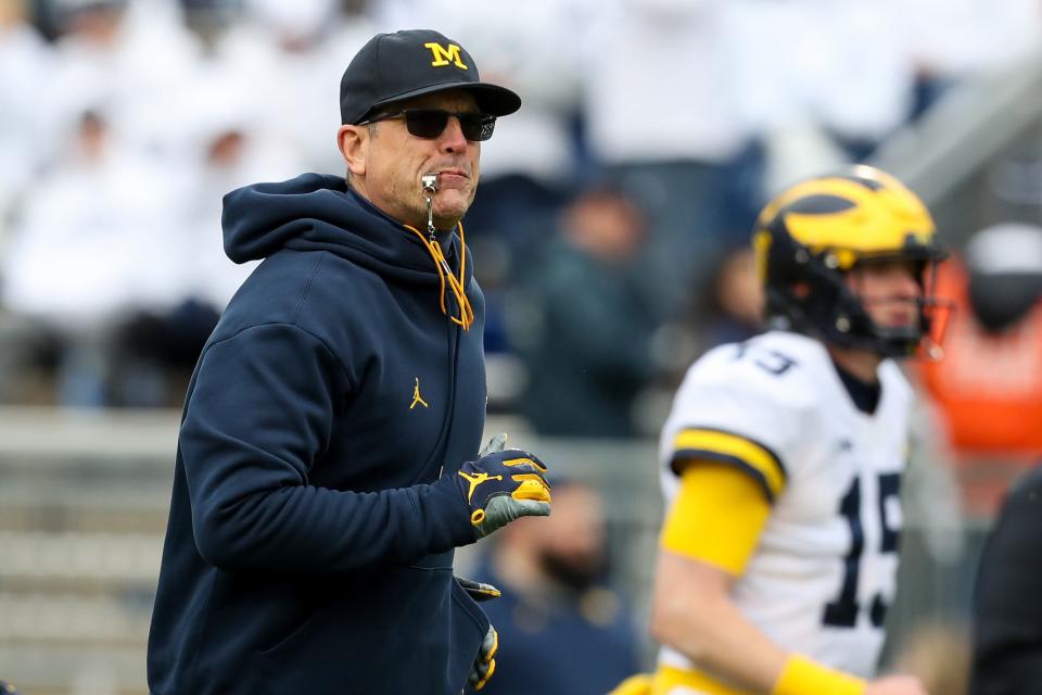 Michigan Wolverines head coach Jim Harbaugh runs on the field during warmups prior to the game against the Penn State Nittany Lions at Beaver Stadium, Nov. 13, 2021 in University Park, Penn.