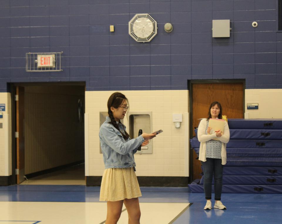 Teacher Margaret Moore listens in the distance as Northern State University student Cheng Chen speaks in front of the Simmons Middle School language club last week.