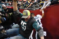 Fans falls onto Philadelphia Eagles quarterback Jalen Hurts (1) after the railing collapsed following the end of an NFL football game, Sunday, Jan. 2, 2022, in Landover, Md. Philadelphia won 20-16. (AP Photo/Alex Brandon)