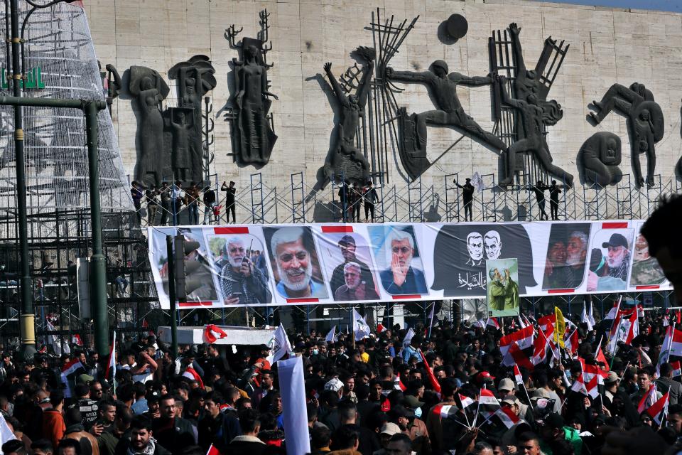 Supporters of the Popular Mobilization Forces hold a posters of Abu Mahdi al-Muhandis, deputy commander of the Popular Mobilization Forces, front, and General Qassem Soleimani, head of Iran's Quds force during a protest, in Tahrir Square, Iraq, Sunday, Jan. 3, 2021. Thousands of Iraqis converged on a landmark central square in Baghdad on Sunday to commemorate the anniversary of the killing of Soleimanil and al-Muhandis in a U.S. drone strike. (AP Photo/Khalid Moha