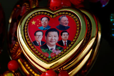 A picture shows a souvenir featuring portraits of former Chinese leaders Mao Zedong (top L), Deng Xiaoping (top R), Jiang Zemin (bottom L), Hu Jintao (bottom R) and current President Xi Jinping as it is sold on Tiananmen Square on the second day of plenary sessions of the 18th Central Committee of the Communist Party of China (CPC) in Beijing, China, October 25, 2016. REUTERS/Thomas Peter