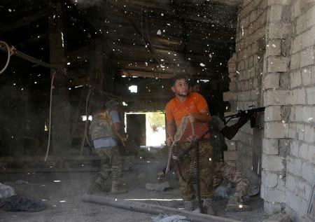 Pieces of bricks fly off the wall as Islamic State fighters open fire at Libyan forces allied with the U.N.-backed government during a battle in Sirte, Libya. REUTERS/Goran Tomasevic