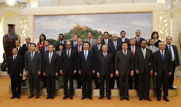 Chinese President Xi Jinping (C) takes photos with guests of the Asian Infrastructure Investment Bank at the Great Hall of the People in Beijing on October 24, 2014