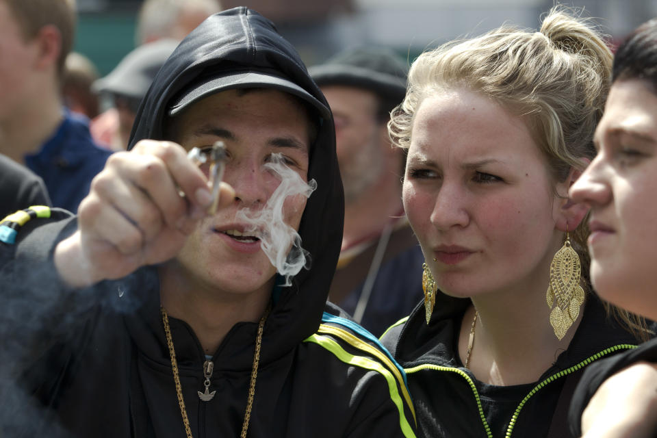 A demonstrator offers the photographer a marijuana joint during a protest rally against the new marijuana buying policy in Maastricht, southern Netherlands, Tuesday May 1, 2012. A policy barring foreign tourists from buying marijuana in the Netherlands goes into effect in parts of the country Tuesday, with a protest planned in the southern city of Maastricht. Weed is technically illegal in the Netherlands, but it is sold openly in small amounts in designated cafes under the country's famed tolerance policy. The government has said that as of May 1, only holders of a "weed pass" will be allowed to purchase the drug, and nonresidents aren't eligible. (AP Photo/Peter Dejong)