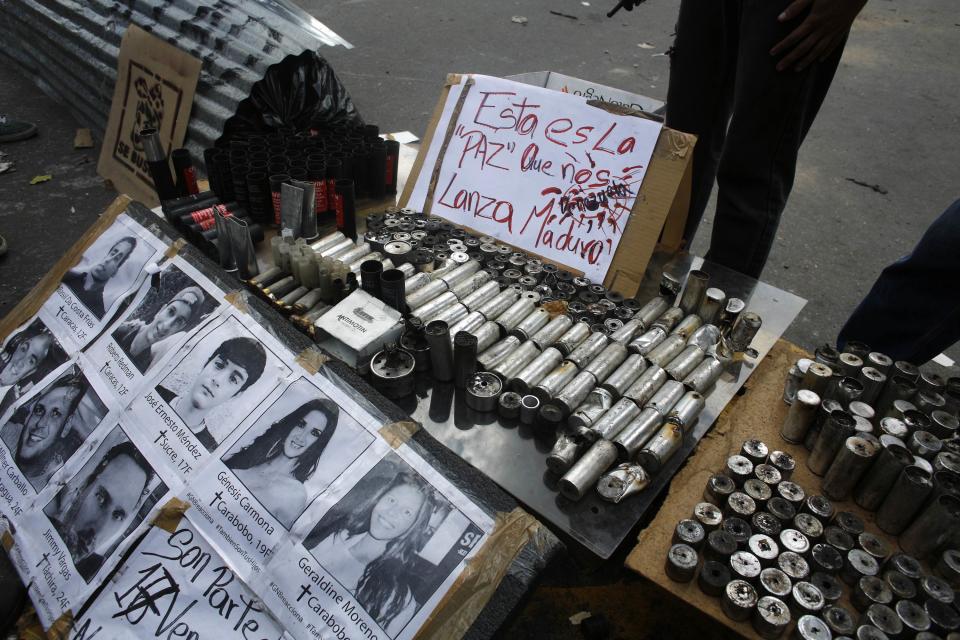 Anti-government protesters display tear gas canisters used by the police during clashes at Altamira square in Caracas