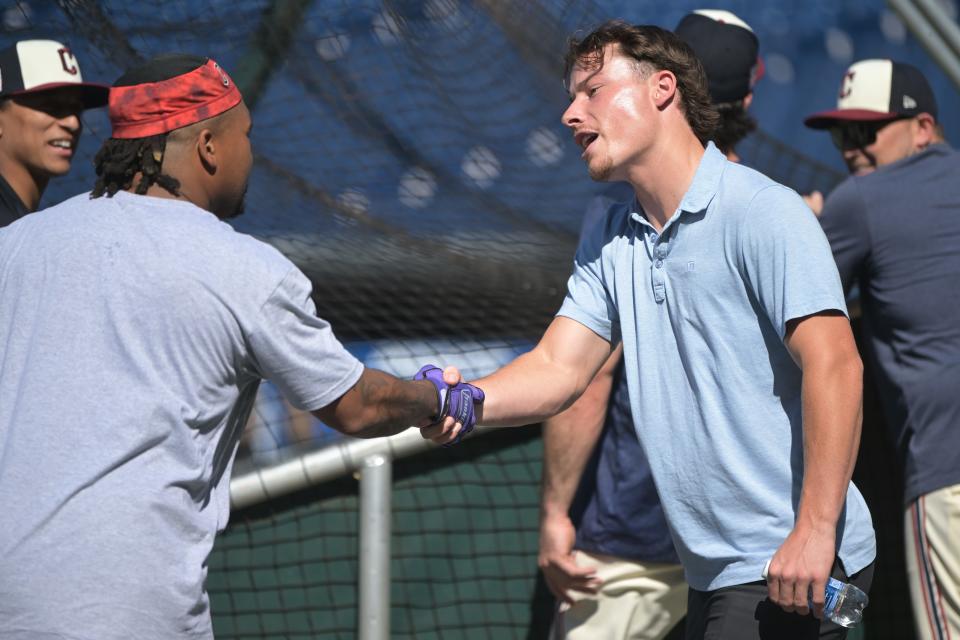 Cleveland Guardians No. 1 draft pick Travis Bazzana, right, shakes hands with third baseman Jose Ramirez (11) before a game between the Guardians and San Diego Padres on Friday at Progressive Field.