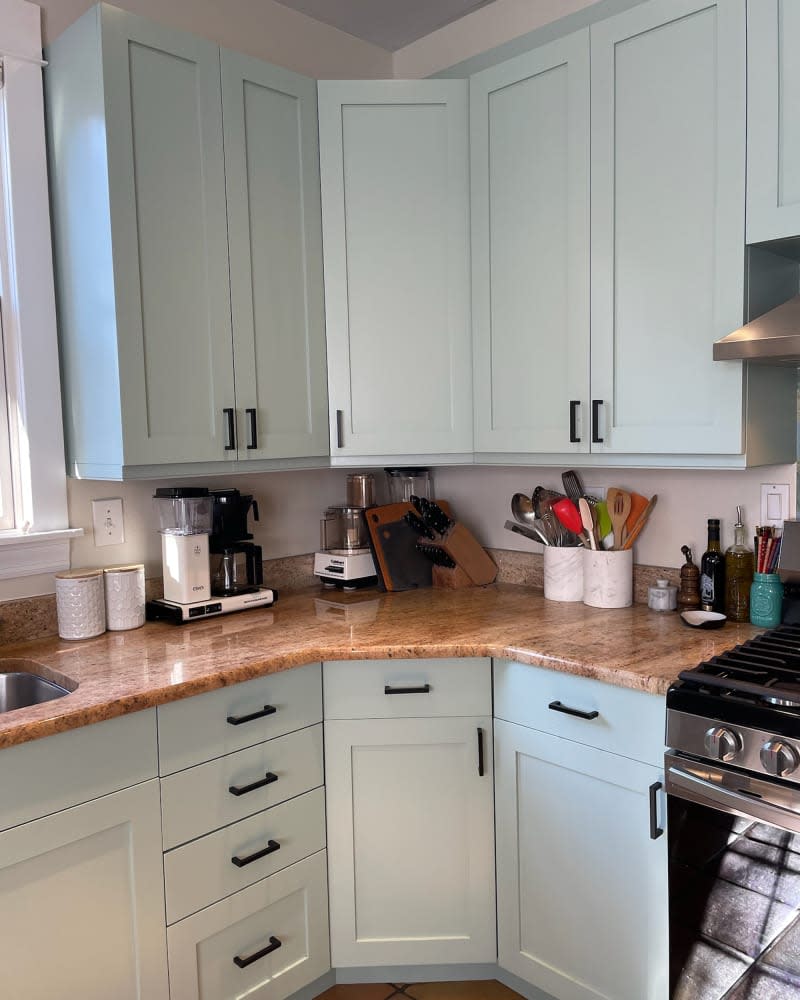 Green cabinets in kitchen after renovation.