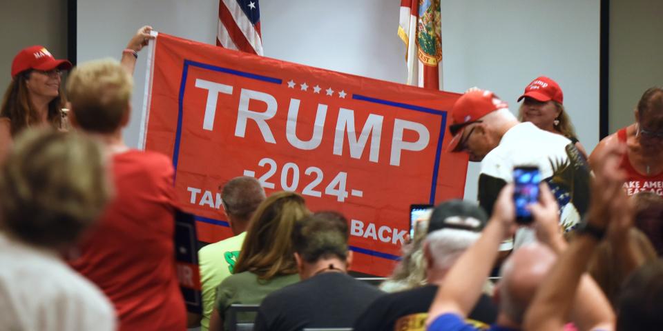 People hold a Trump 2024 flag before Republican Rep. Matt Gaetz of Florida arrives to address supporters at a Matt Gaetz Florida Man Freedom Tour event at the Hilton Melbourne Beach on July 31, 2021.