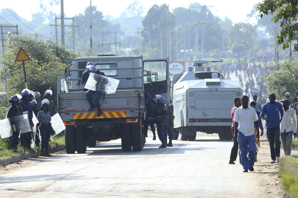 Riot police are seen on a street during a demonstration over the hike in fuel prices in Harare, Zimbabwe, Monday, an. 14, 2019. Zimbabwean President Emmerson Mnangagwa has more than doubled the price of gasoline, hoping the increase will end severe shortages that are fueling public anger even as he departs on a foreign trip to Russia and other countries in search of investment. (AP Photo/Tsvangirayi Mukwazhi)