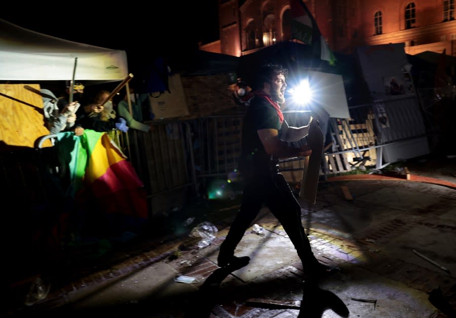 LOS ANGELES, CALIFORNIA – May 1: Pro-Palestinian protestors defend themselves against a pro-Israeli supporter at an encampment at UCLA early Wednesday morning. (Wally Skalij/Los Angeles Times via Getty Images)