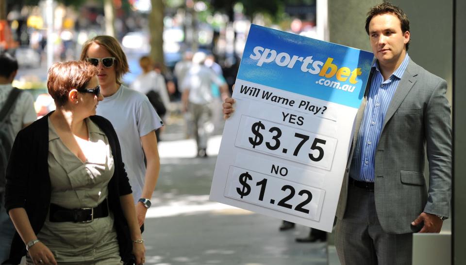 An employee for Sportsbet holds a sign advertising betting odds for a cricket match in 2010. <a href="https://www.gettyimages.com/detail/news-photo/haydn-lane-from-sportsbet-com-au-holds-up-the-odds-of-news-photo/107565307?adppopup=true" rel="nofollow noopener" target="_blank" data-ylk="slk:William West/AFP via Getty Images;elm:context_link;itc:0;sec:content-canvas" class="link ">William West/AFP via Getty Images</a>