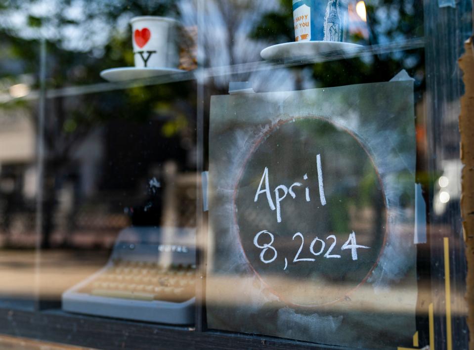 A sign advertising the day of the total solar eclipse is seen in the window of Your Brother's Bookstore in downtown Evansville, Ind., Friday, March 29, 2024.