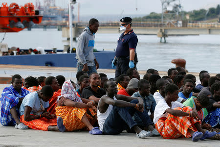 FILE PHOTO: Migrants sit after they disembarked from the vessel Topaz Responder in the Sicilian harbour of Augusta, Italy September 7, 2016. REUTERS/Antonio Parrinello/File Photo