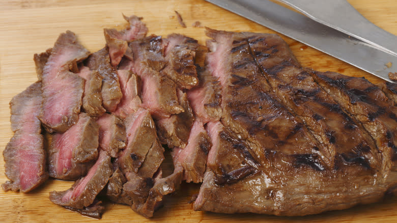 Flank steak cut into slices with knives