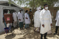 In this photo taken Thursday, May 21, 2020, a delegation led by Mali's Minister of Health Michel Sidibe, right, visits the isolation tent for patients with the coronavirus in Timbuktu, Mali. COVID-19 has made its way to Timbuktu, a town whose name has long been synonymous around the world with remoteness. (AP Photo/Baba Ahmed)