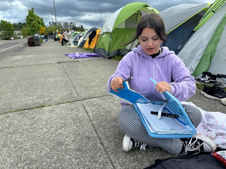 Lauren Tibbett, 23, of Yakima keeps the unofficial roster of campers Monday who will be the first enter the Tacoma Dome Tuesday to see K-pop sensation Tomorrow X Together. Craig Sailor/The News Tribune