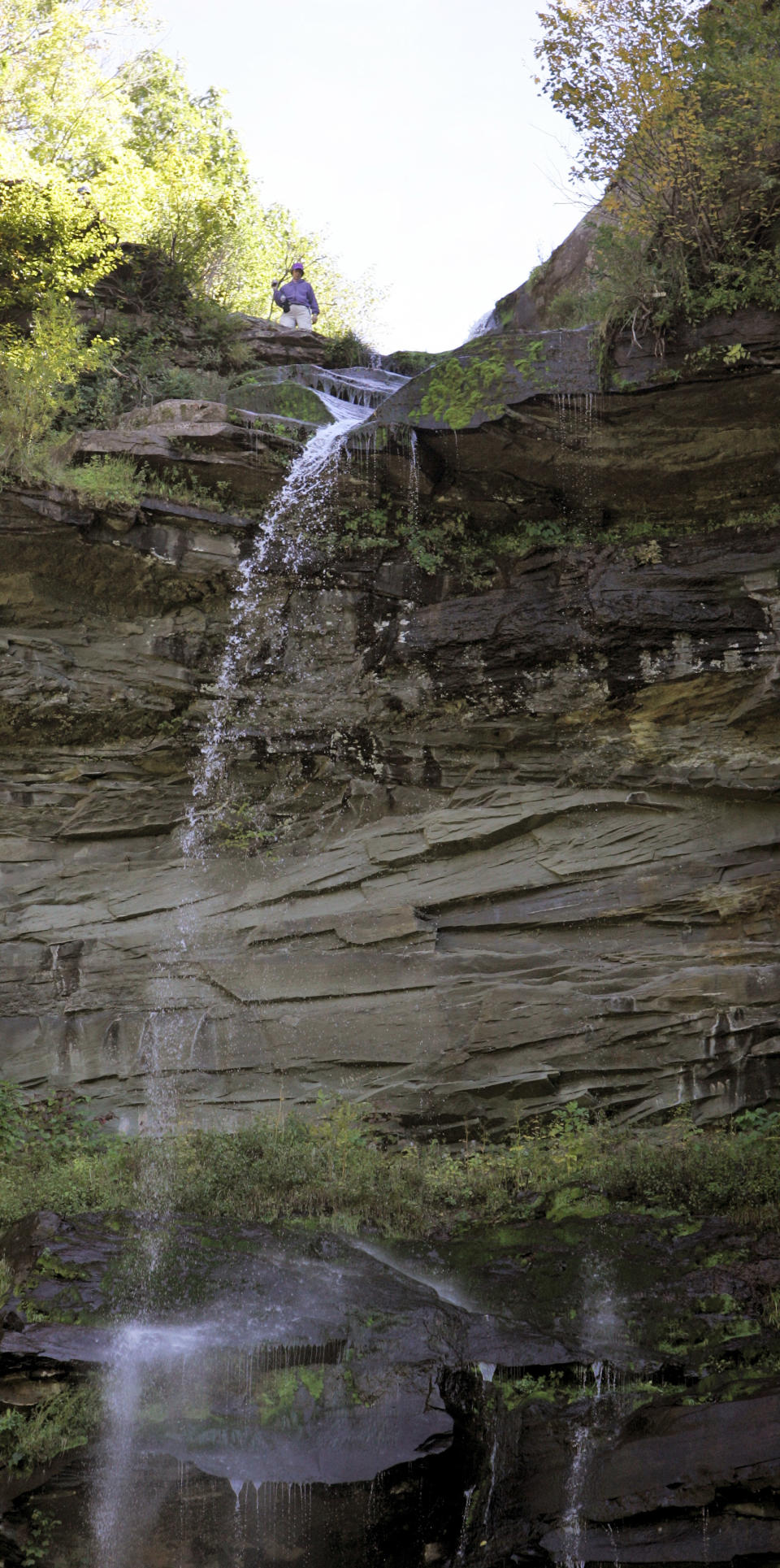 FILE - This Sept. 30, 2005 file photo shows a visitor on top of the 260 foot high Kaaterskill Falls outside Catskill, N.Y., looking toward the Catskill Mountains. The Catskill Mountains, rising up west of the river, offer dozens of trails though pretty woods that lead to great views. Many trails are suitable for family hikes, like the roughly 2-mile round trip to Kaaterskill Falls near Palenville. (AP Photo/Jim McKnight, File)