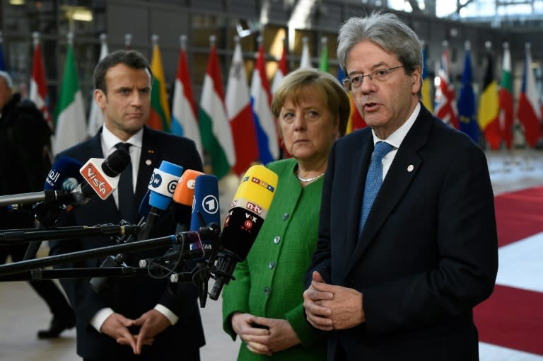 Former Italian premier Paolo Gentiloni (right) speaks to journalists next to German Chancellor Angela Merkel and French President Emmanuel Macron at a meeting of EU leaders in February