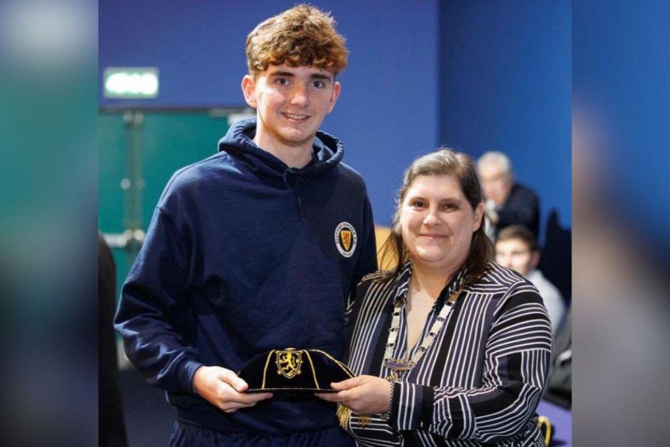 Owen Doyle is presented with Scotland cap by Gillian Duffy <i>(Image: St Columba's High School)</i>