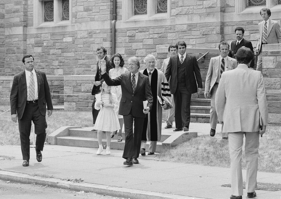 FILE - In this June 9, 1977 file photo, President Jimmy Carter waves as he departs the First Baptist Church in Washington with daughter Amy and daughter-in-law Caron Carter. The Rev. Charles Trentham, pastor of the church, is at right. At Washington churches, presidents have long been seated in the pews. Bill and Hillary Clinton favored a Methodist church. Jimmy Carter taught Baptist Sunday School. And Barack Obama dropped in at an Episcopal church next to the White House. But as Easter Sunday approaches, President Donald Trump has not attended a church service in the Capitol since the worship events during his inauguration weekend. (AP Photo, File)