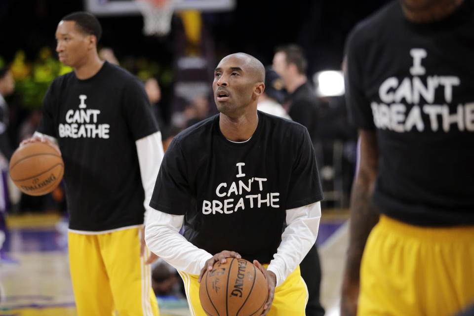 Los Angeles Lakers' Kobe Bryant, center, warms up before an NBA basketball game against the Sacramento Kings in Los Angeles, Dec. 9, 2014. (AP Photo/Jae C. Hong)