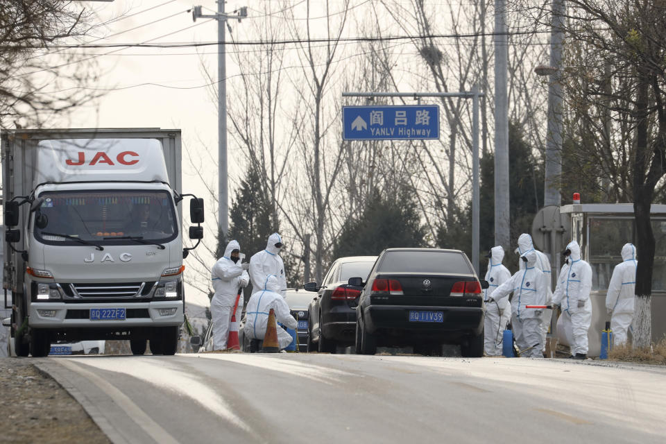 Workers disinfect passing vehicles in an area having the latest incident of African swine flu outbreak on the outskirts of Beijing, China, Friday, Nov. 23, 2018. Reeling from rising feed costs in Beijing's tariff fight with U.S. President Donald Trump, Chinese pig farmers face a new blow from an outbreak of African swine fever that has sent an economic shockwave through the countryside. (AP Photo/Ng Han Guan)