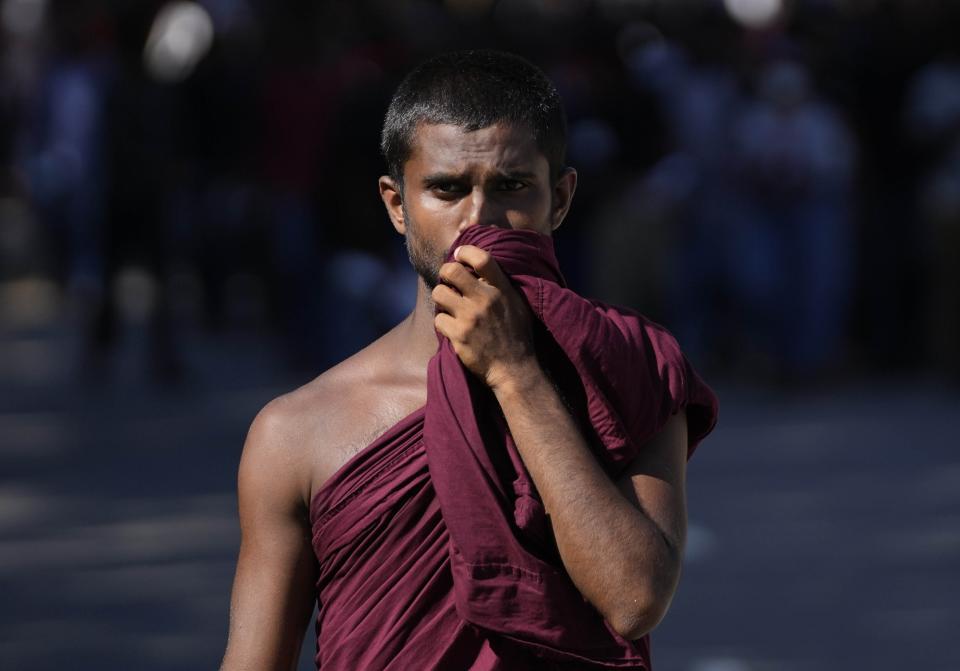 A Buddhist monk listens to an anti-government speech during the ongoing protest outside president's office in Colombo, Sri Lanka, Monday, April 25, 2022. Thousands of Sri Lankans have protested outside President Gotabaya Rajapaksa’s office in recent weeks, demanding that he and his brother, Mahinda, who is prime minister, quit for leading the island into its worst economic crisis since independence from Britain in 1948. (AP Photo/Eranga Jayawardena)
