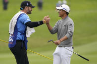 Collin Morikawa greets his caddie Jonathan Jakovac on the 18th hole after their final round of the PGA Championship golf tournament at TPC Harding Park Sunday, Aug. 9, 2020, in San Francisco. (AP Photo/Charlie Riedel)