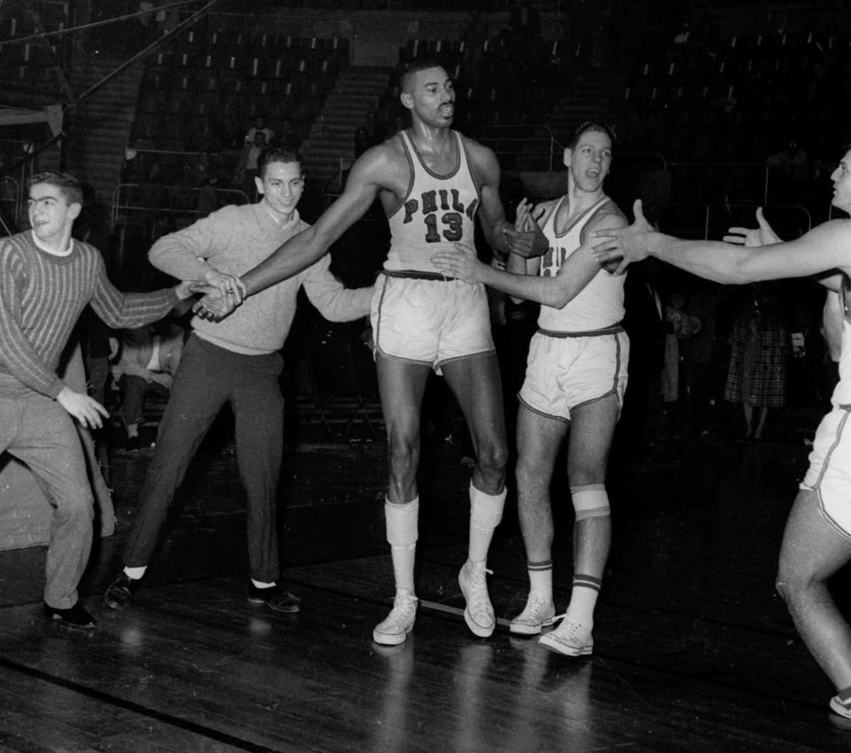 Teammates and fans congratulate Wilt Chamberlain after he scored 100 points to lead the Philadelphia Warriors to a 169-147 win over the New York Knickerbockers on March 2, 1962.