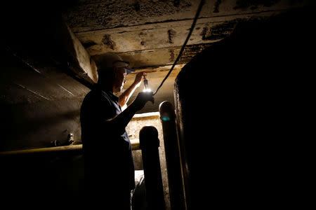 Eleazar Azuaje, who is in charge of looking after the water system for the apartment block, checks the water level of the main tank of the building in Caracas, Venezuela, March 18, 2019. REUTERS/Carlos Garcia Rawlins