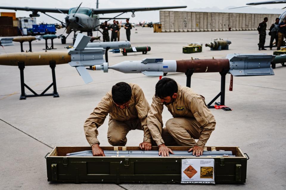 Two troops put weapons in a container.